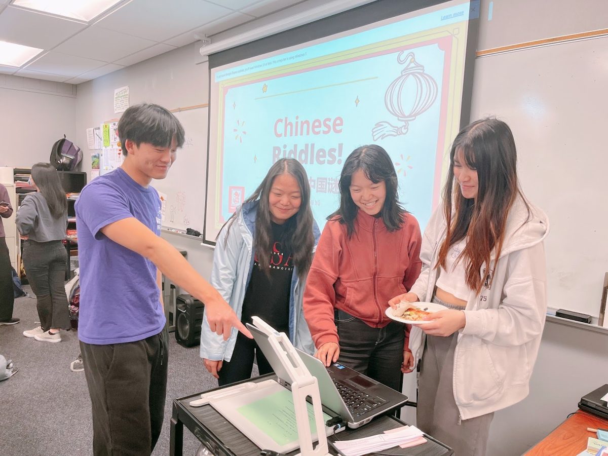 The CHS club officers gather around the computer projecting the slides before the start of their meeting on Chinese Riddles. | Photo by Crystal Cheng