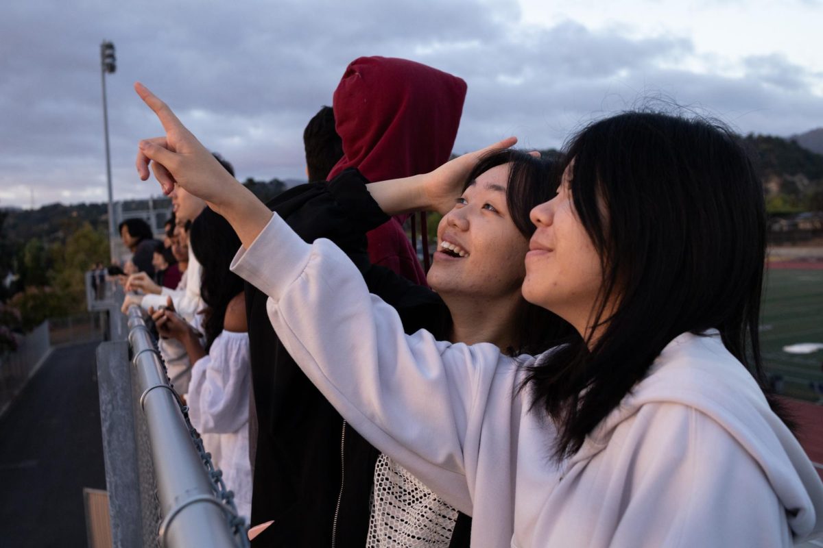 Seniors Michelle Dong and Katie Wang watch the sunrise together. Participants of Senior Sunrise often attended and watched the sunrise with their group of friends