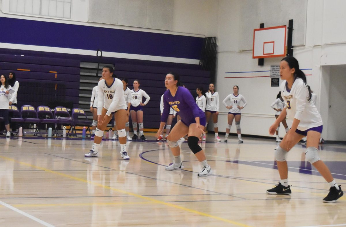 Senior outside hitter Kiana Mark, sophomore outside hitter Emily Chan and junior libero Victoria Woo take a preparatory stance in the backcourt. Photo by Eric Zhou