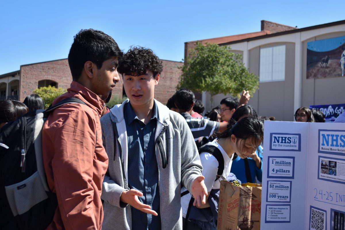 Senior Steve Yang (right) presents his club trifold to another student during Club Information Day on Thursday, Sept. 19. 
