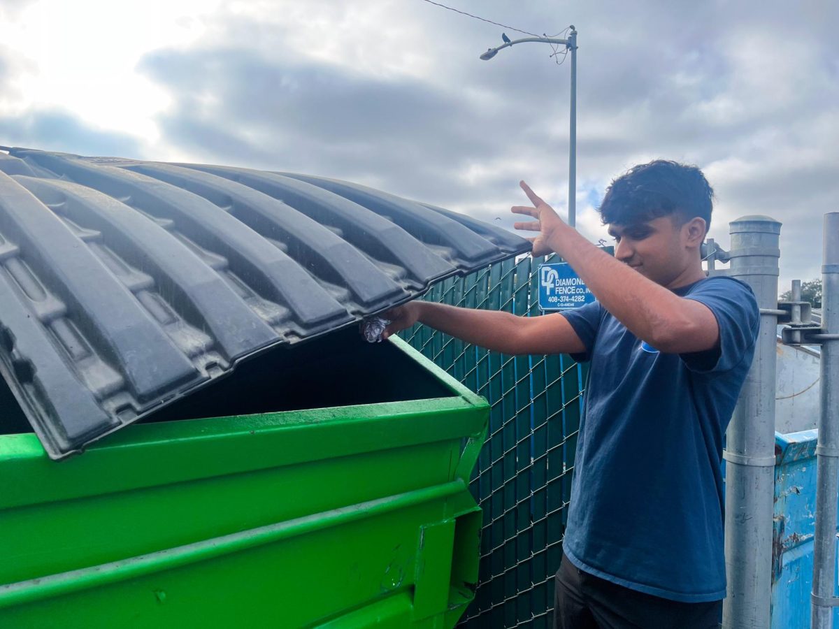 Senior Arjun Dhruv disposes paper in the recycling bin.