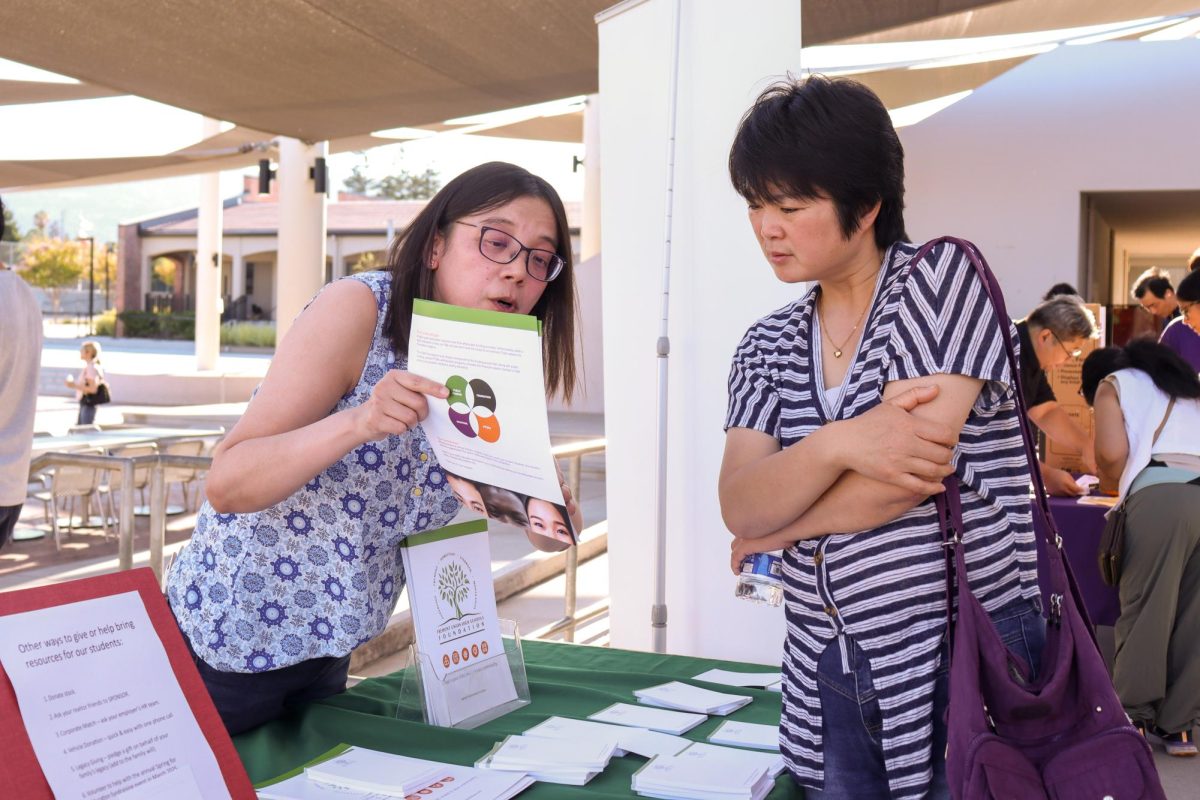 A member of the FUHS Foundation speaks to a parent about how to get involved with the school district.