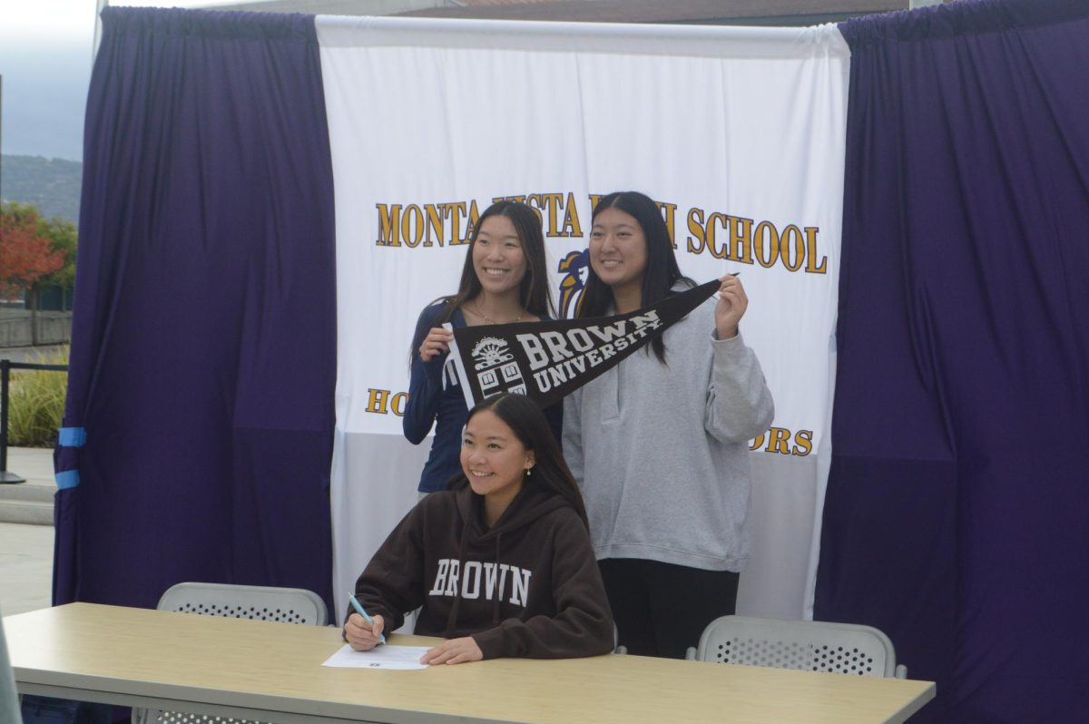 Senior Clara Fan takes a photo with her friends during her signing