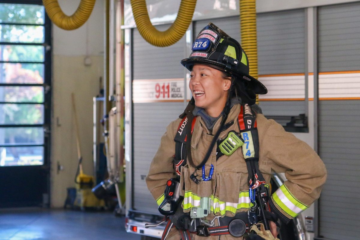 Firefighter engineer Ruri Kobayakawa dons her protective gear as she converses with a colleague. 

Photo | Liz Liu