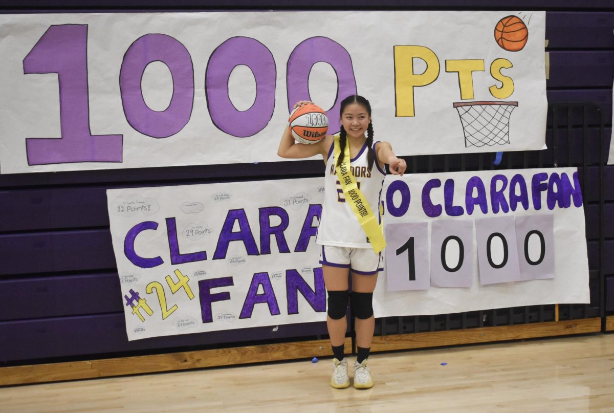 Senior Clara Fan poses for a photo after the game with a homemade sash and a basketball signed by her teammates. Photo | Leah Desai