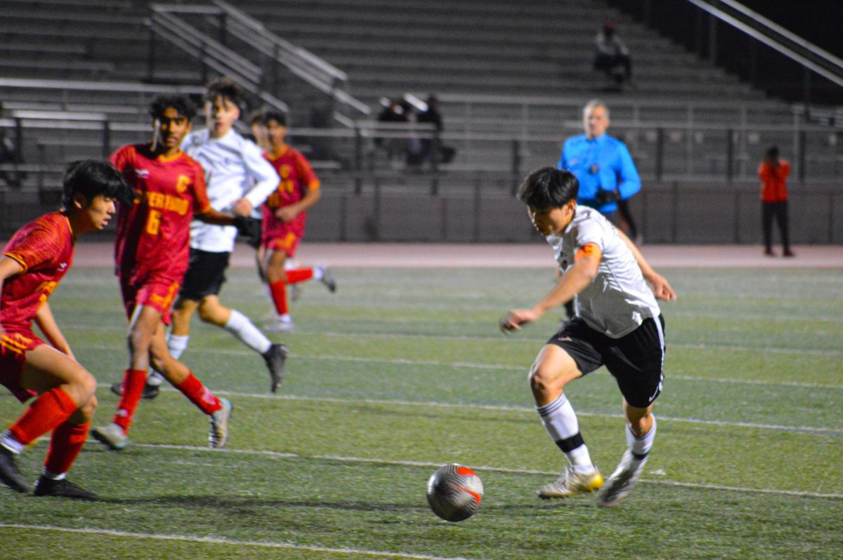 Senior and striker Royce Tse dribbles while a CHS defender attempts to steal the ball.