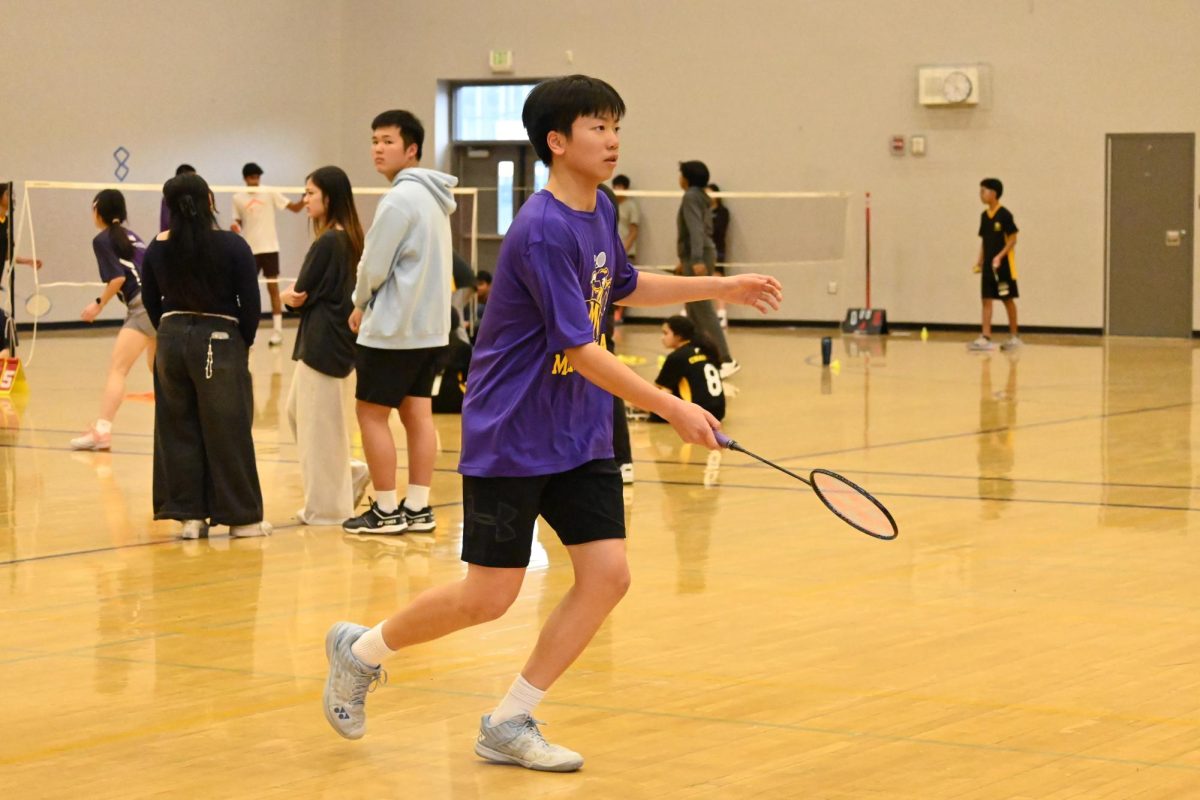 Freshman Aiden Wong runs to hit the birdie in his boys singles game.
