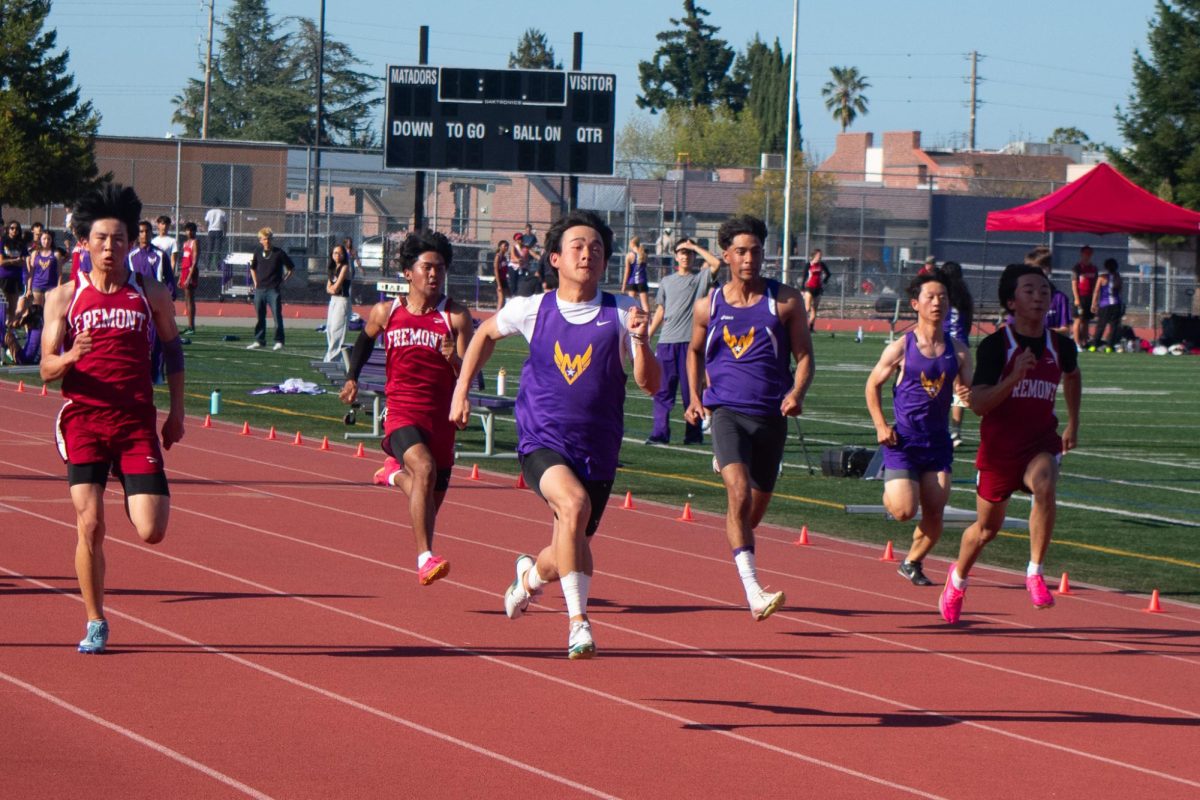 junior Jayden Tang runs across the track as they approach the finish line during the 100-meter dash.