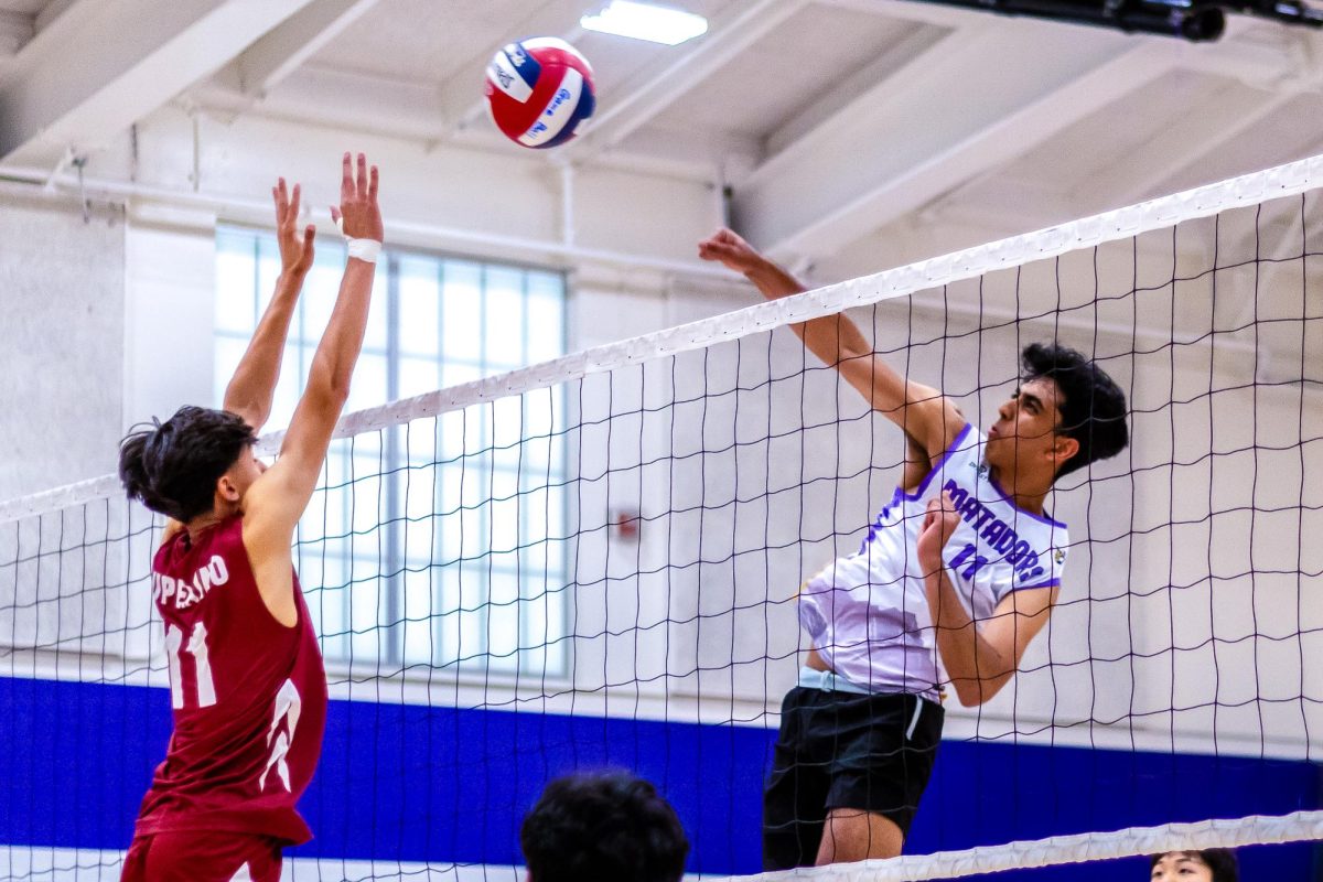 Junior and middle hitter Pratham Kannan hits the ball over the net to trip up CHS’ blockers. 