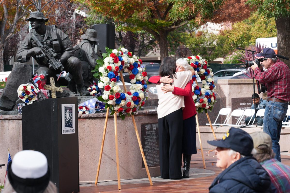 Relatives of Navy SEAL Matthew Axelson share a hug during a wreath-laying ceremony honoring his service in front of his memorial. Photo | Maahi Dev
