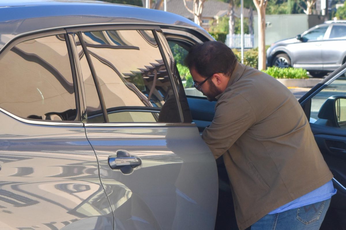 A volunteer hands a box of food to a family in the drive-through food distribution. Photo | Sophia D'Sa
