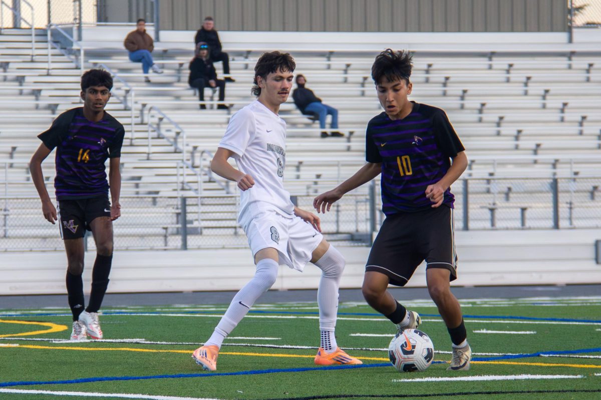 Senior and midfielder Bhanu Raut pivots with the ball to evade a HHS defender. 

Photo | Owen Liu
