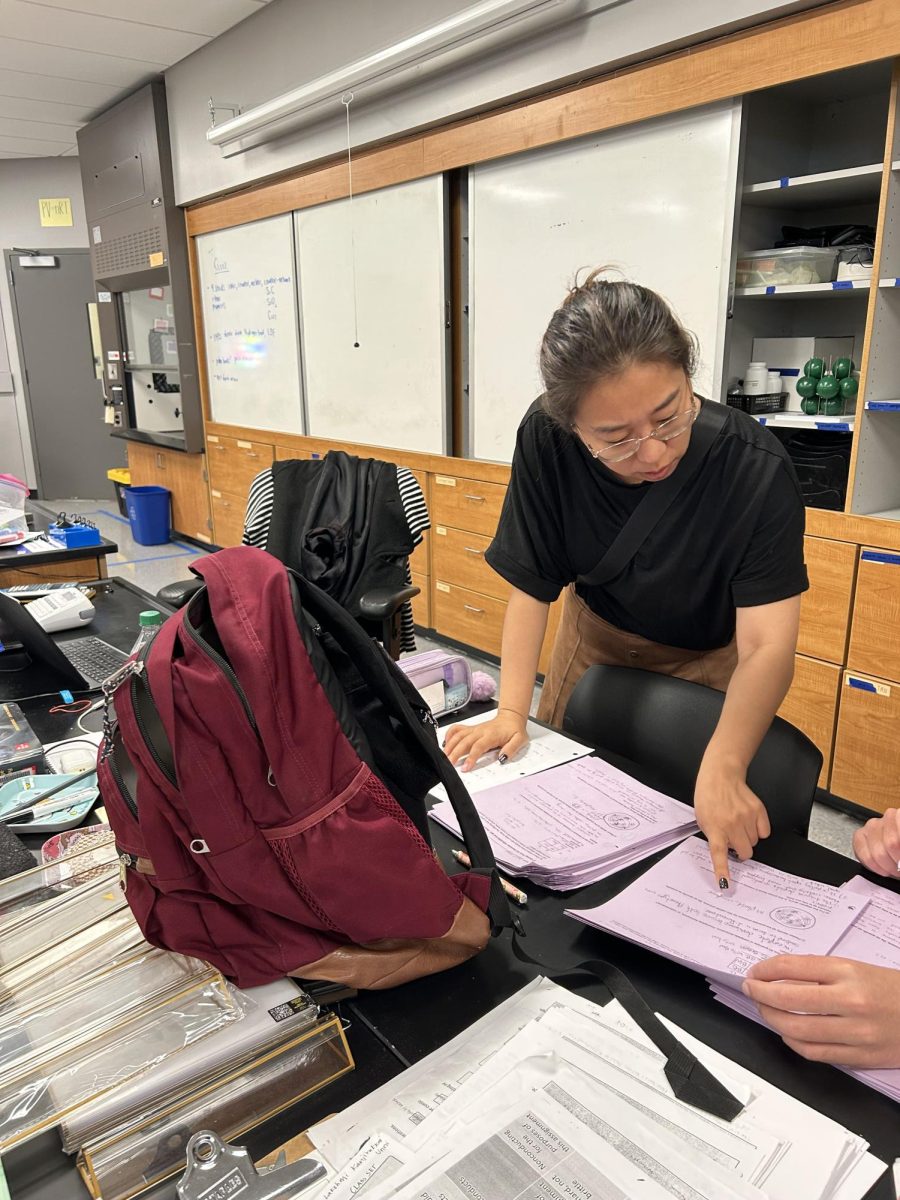 Sooyoung Choi points out something on an exam response to a TA as she prepares to transfer classrooms. Photo | Kai Tsuchida
