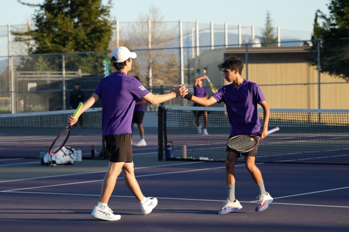 Doubles partners sophomore Aditya Kumar and senior Andrew Ryu high-five each other after a point. Photo | Maahi Dev