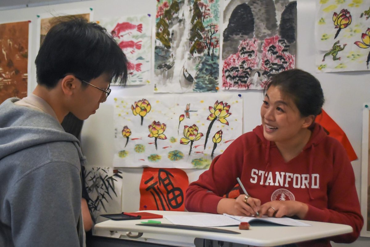 Liu interacts with a student as she corrects homework. Photo | Olivia Zhang