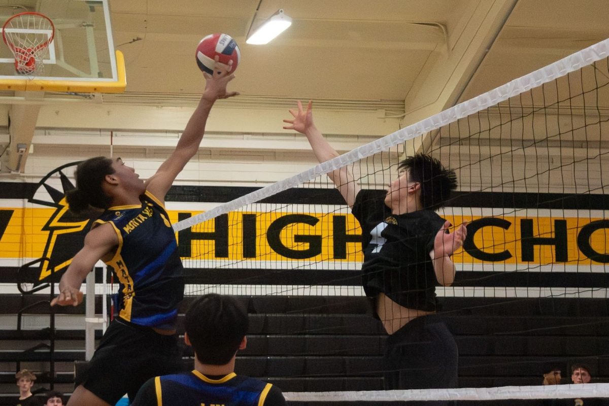 Sophomore middle blocker Isaiah Slade tips the ball in a different direction than the player on the opposition. 

Photo | Divina Pandita-Raina