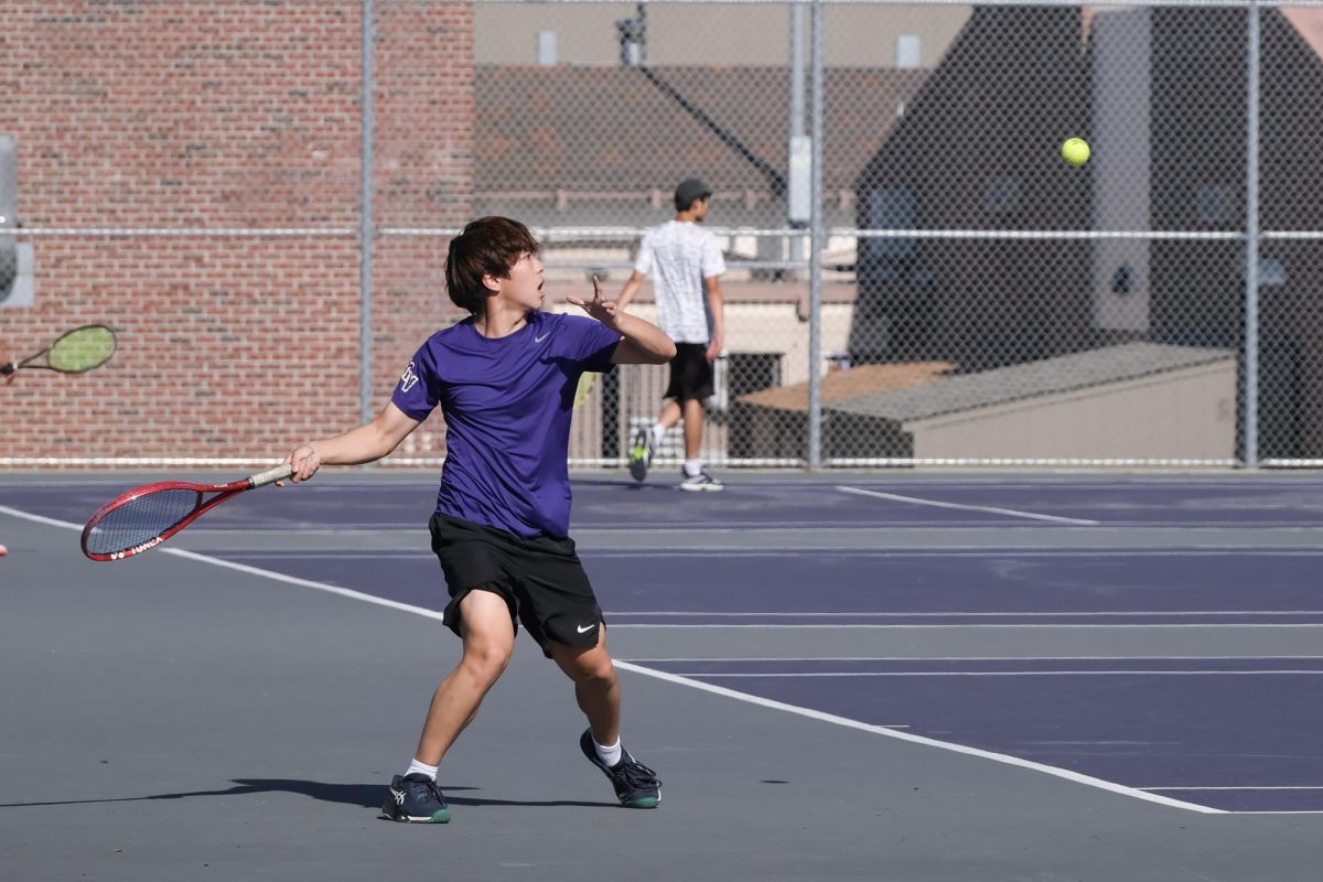 Sophomore and doubles player Stanley Zhang draws his racket back to hit a ball on his forehand. Photo | Emma Ma